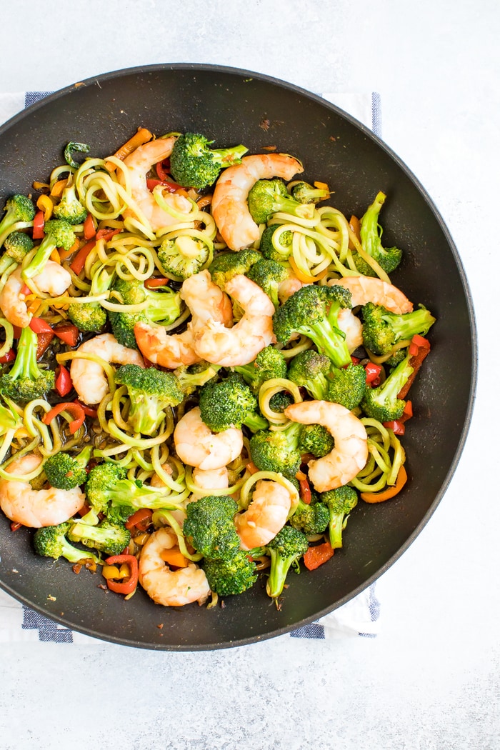Healthy, broccoli noodle stir fry in a skillet with broccoli, carrots, peppers and teriyaki shrimp.