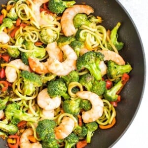 Healthy, broccoli noodle stir fry in a skillet with broccoli, carrots, peppers and teriyaki shrimp.