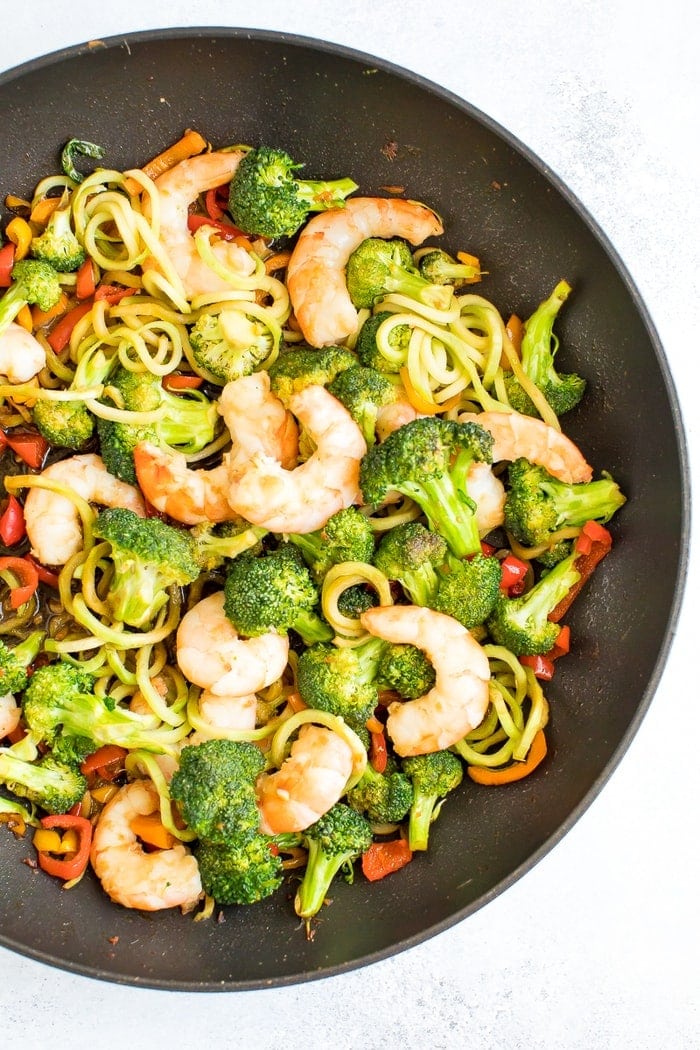 Healthy, broccoli noodle stir fry in a skillet with broccoli, carrots, peppers and teriyaki shrimp.