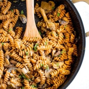 A skillet of healthy, protein-packed vegan mushroom stroganoff made with savory mushrooms, lentil pasta and a creamy coconut milk sauce.
