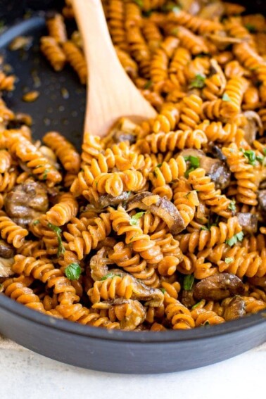 A skillet of healthy, protein-packed vegan mushroom stroganoff made with savory mushrooms, lentil pasta and a creamy coconut milk sauce.