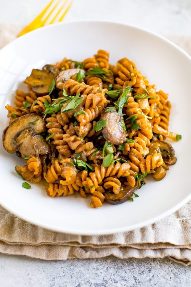 Plate of healthy, one pot vegan mushroom stroganoff made with red lentil pasta.