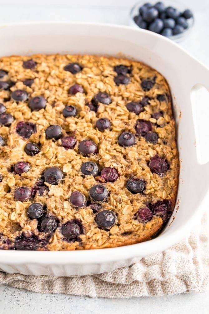Baking dish with Blueberry Baked Oatmeal topped with fresh blueberries.