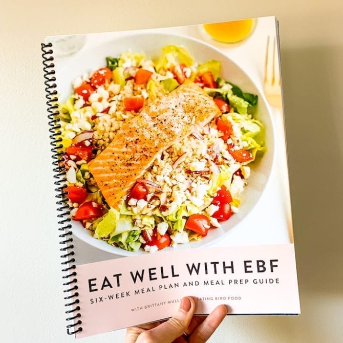 Eat well with EBF spiral bound book held by a woman's hand.