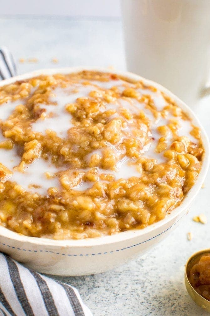 Bowl of creamy, gooey salted caramel oatmeal made with date caramel. Topped with almond milk.