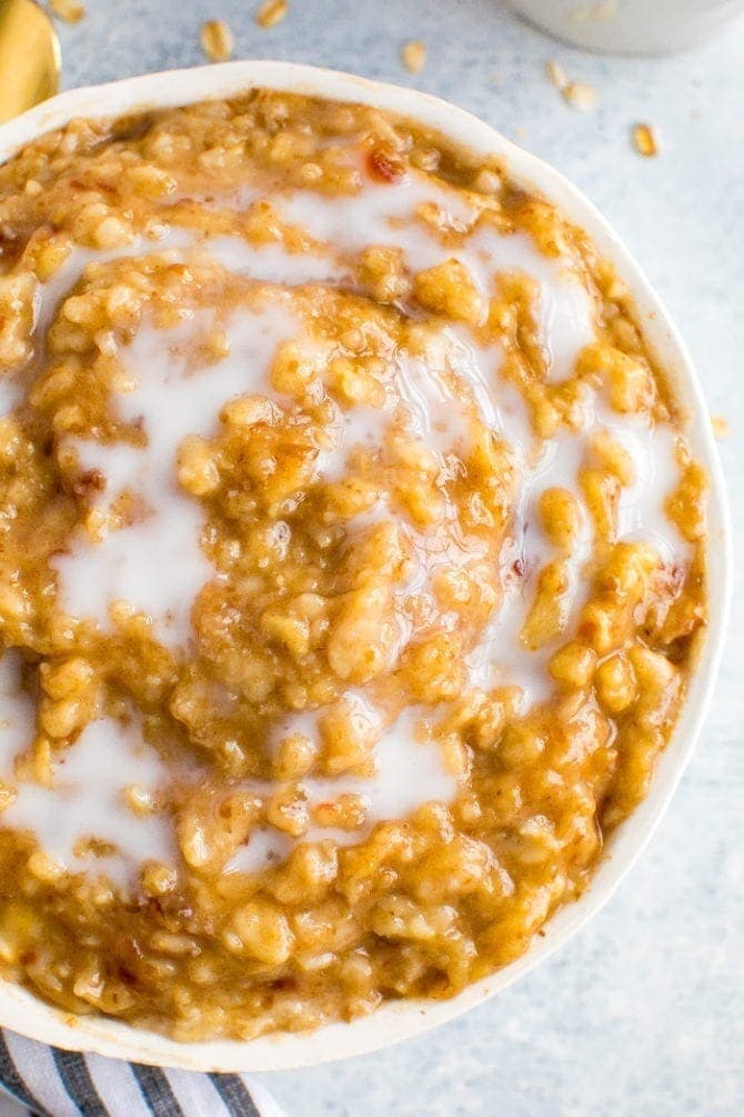 Bowl of creamy, gooey salted caramel oatmeal made with date caramel. Topped with almond milk.
