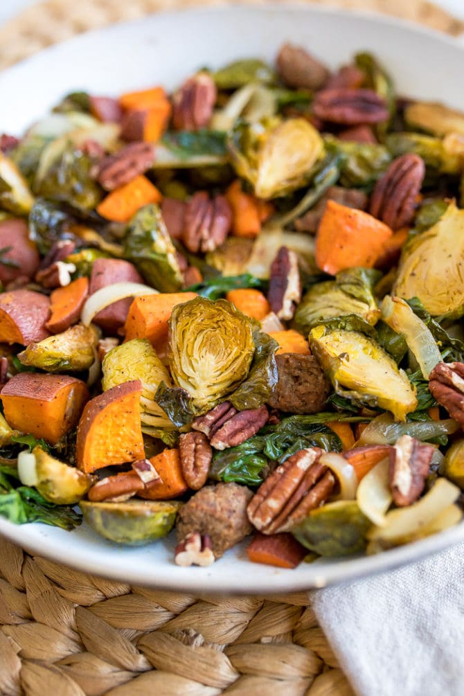 Breakfast hash on a plate with Brussels, pecans, sausage, and roasted sweet potatoes.