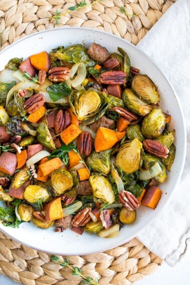 Sweet potato hash with brussel sprouts and pecans on a white plate.