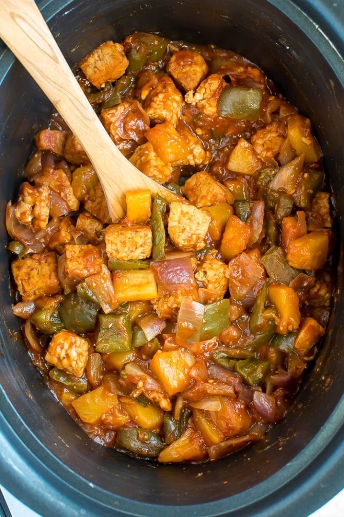 Slow cooker sweet and sour tempeh, pineapple, peppers and onions in a slow cooker.