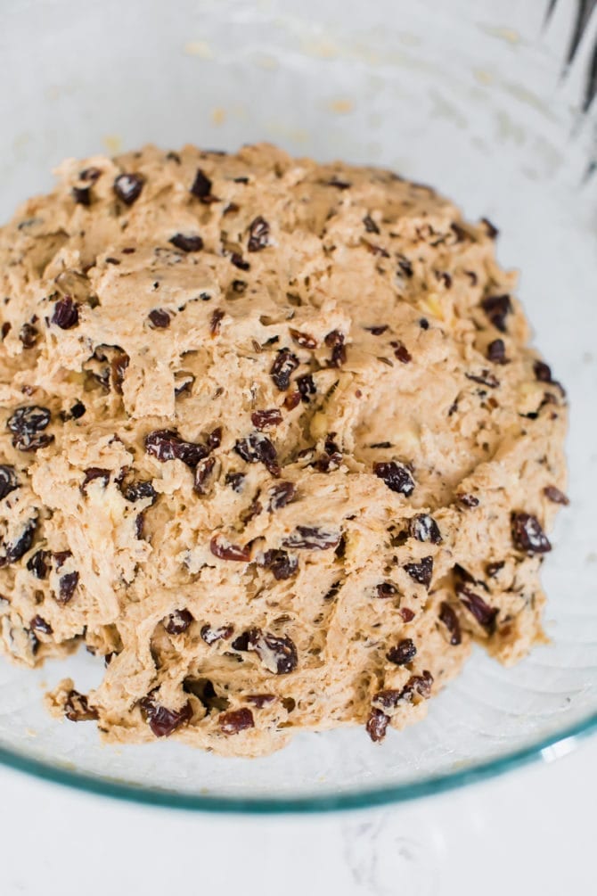 Whole wheat Irish soda bread dough with raisins in a mixing bowl.