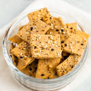 Bowl of homemade crackers topped with Everything But The Bagel Seasoning.