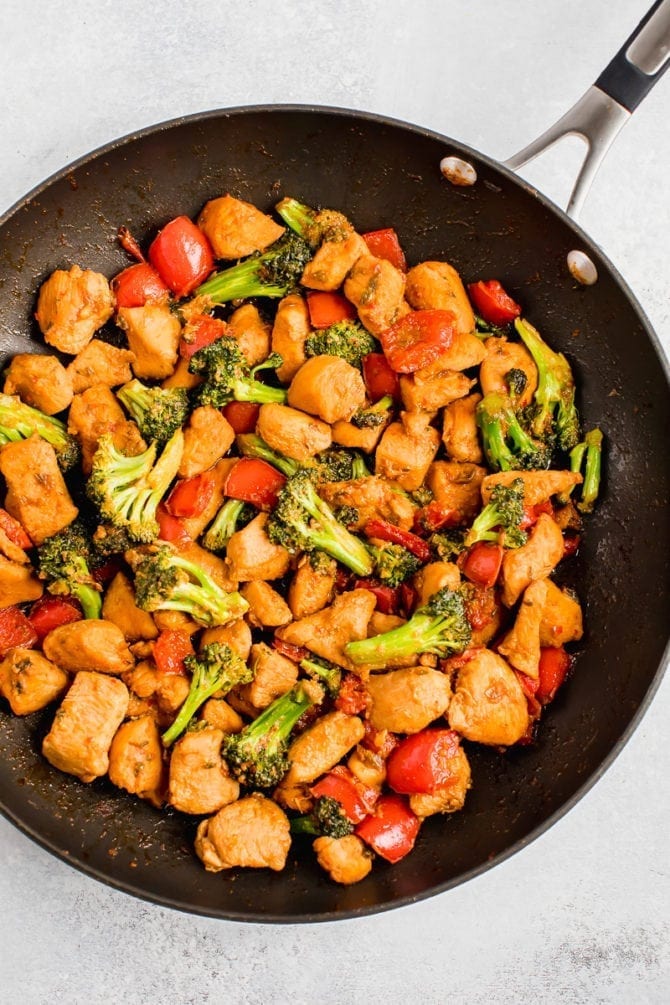 Healthy Kung Pao Chicken in a skillet with peppers and broccoli.