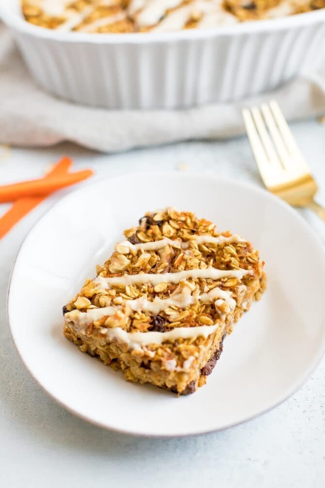 Slice of carrot cake baked oatmeal with a cream cheese drizzle.