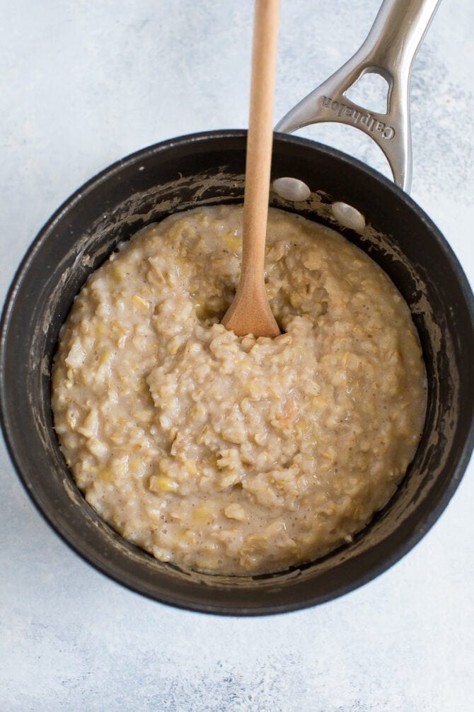 Egg white being stirred into a pot of oatmeal.