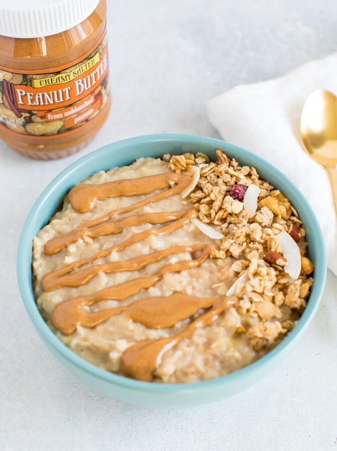 Peanut butter oatmeal with a drizzle of peanut butter and granola on top. 