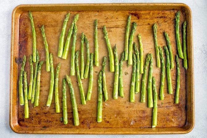 Sheet pan with asparagus, ready to be roasted in the oven.