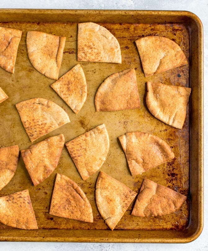 Baked pita chips on a baking sheet.