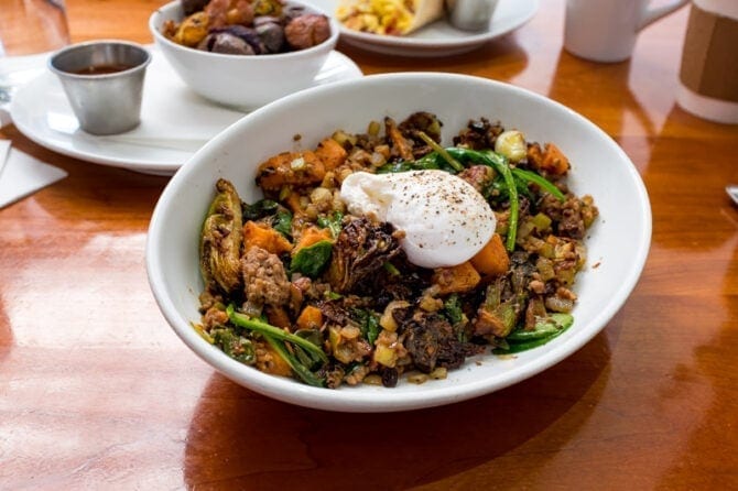 bowl of breakfast veggie hash topped with a poached egg