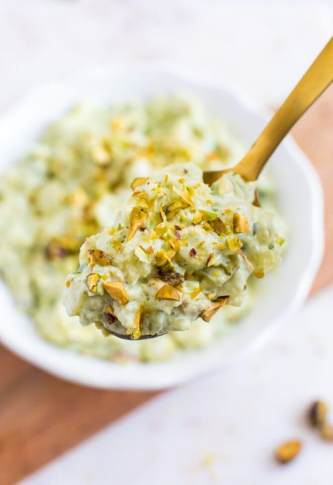 Close up photo of a spoonful of healthy watergate salad, topped with chopped pistachios.