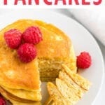 stack of coconut flour pancakes topped with raspberries and maple syrup