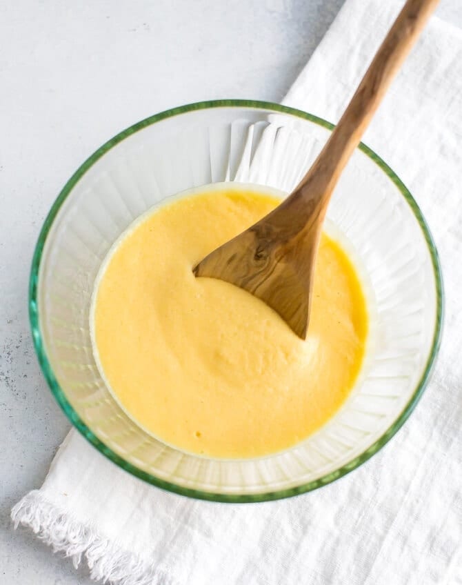 Coconut flour pancake batter in a bowl with a wooden spoon.