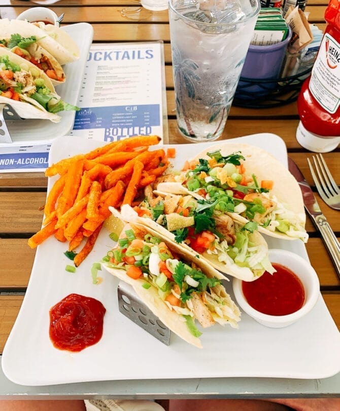 Plate of fish tacos with sweet potato fries.