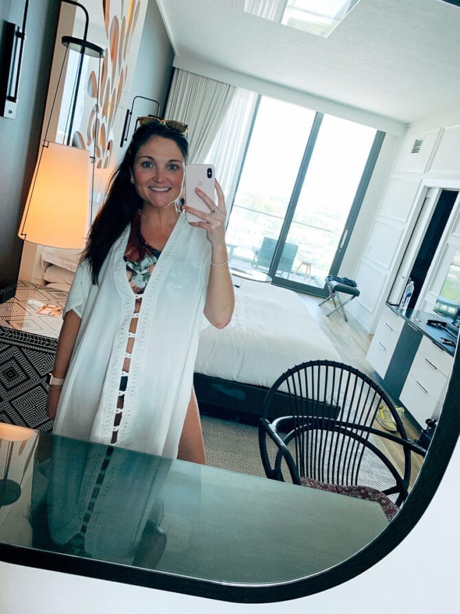 Woman taking a mirror selfie in the room of a Grand Cayman resort.