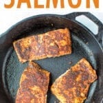 Three pieces of blackened salmon in a cast iron skillet.