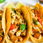 Three asian tofu tacos with baked teriyaki tofu, asian slaw, and cilantro.