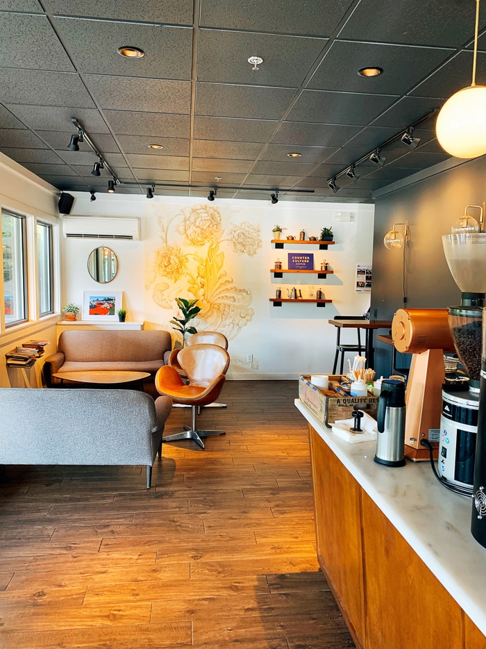 Interior of a coffee shop in Stowe, Vermont with wood floors and plush couches and leather modern chairs.