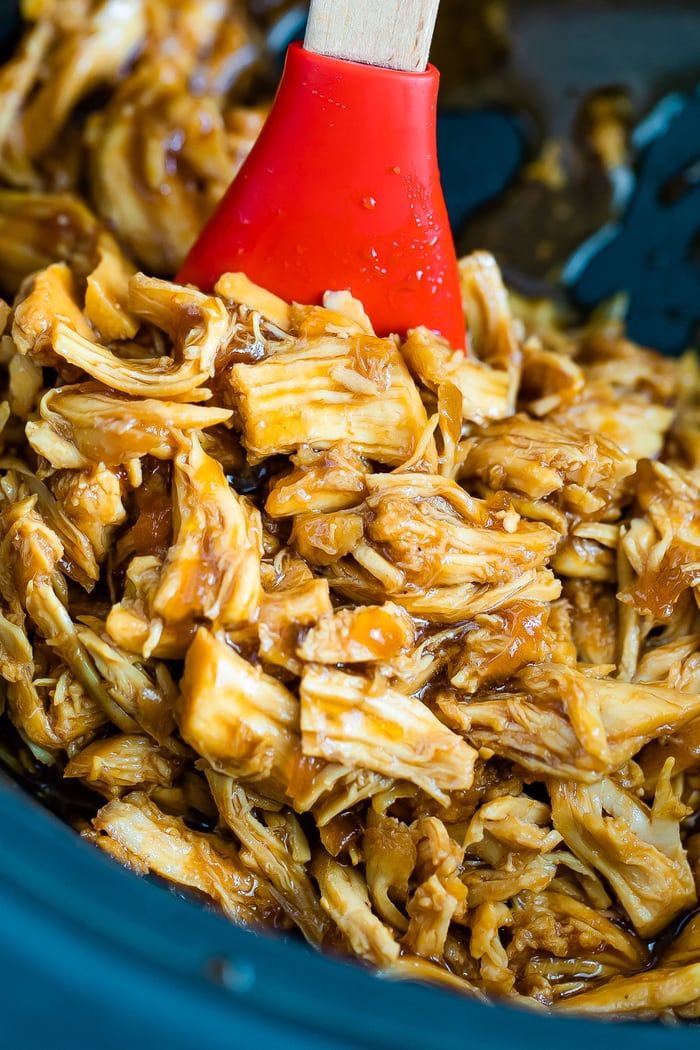 Shredded chicken in a slow cooker with teriyaki sauce.