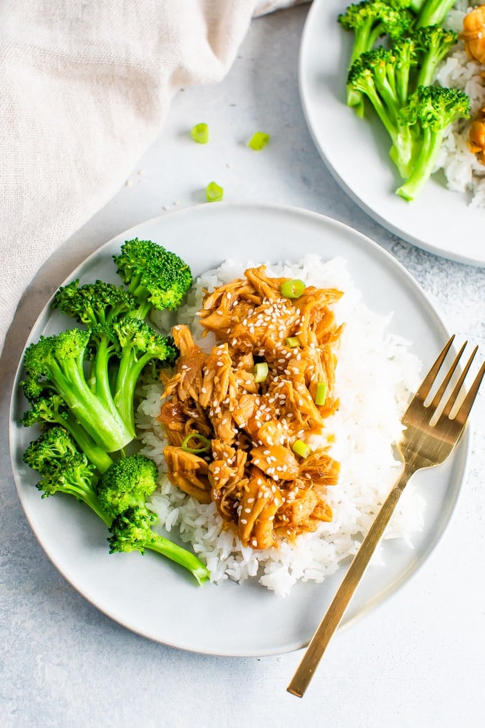 Plate with rice, broccoli, and slow cooker teriyaki chicken. A gold fork is resting on the plate.