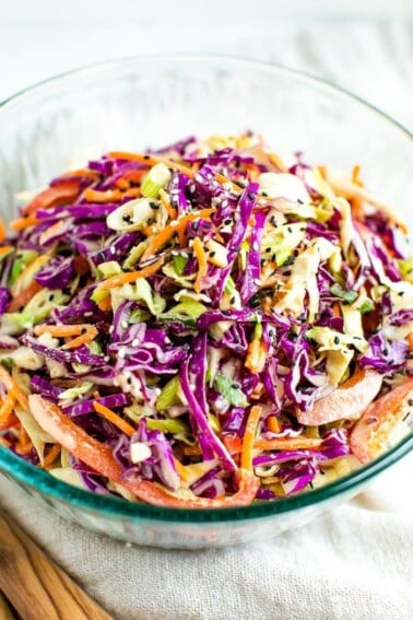 Bowl of asian slaw made with purple cabbage, scallions, peppers and carrots.