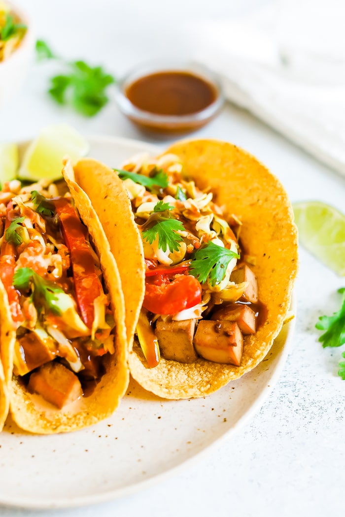 Two asian tofu tacos with baked teriyaki tofu, asian slaw, and cilantro.