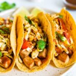 Three asian tofu tacos with baked teriyaki tofu, asian slaw, and cilantro.