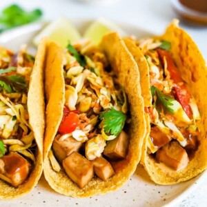 Three asian tofu tacos with baked teriyaki tofu, asian slaw, and cilantro.