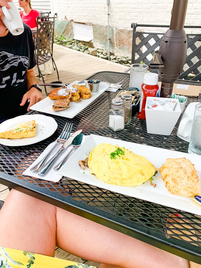 Outdoor table at a restaurant with plates of breakfast food.