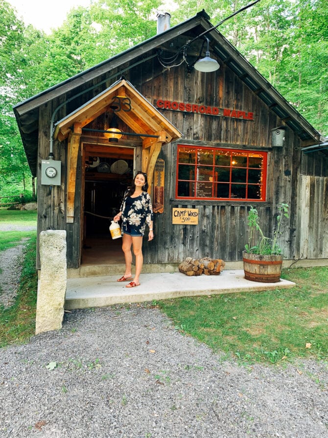 Woman standing in front of a maple syrup shack.