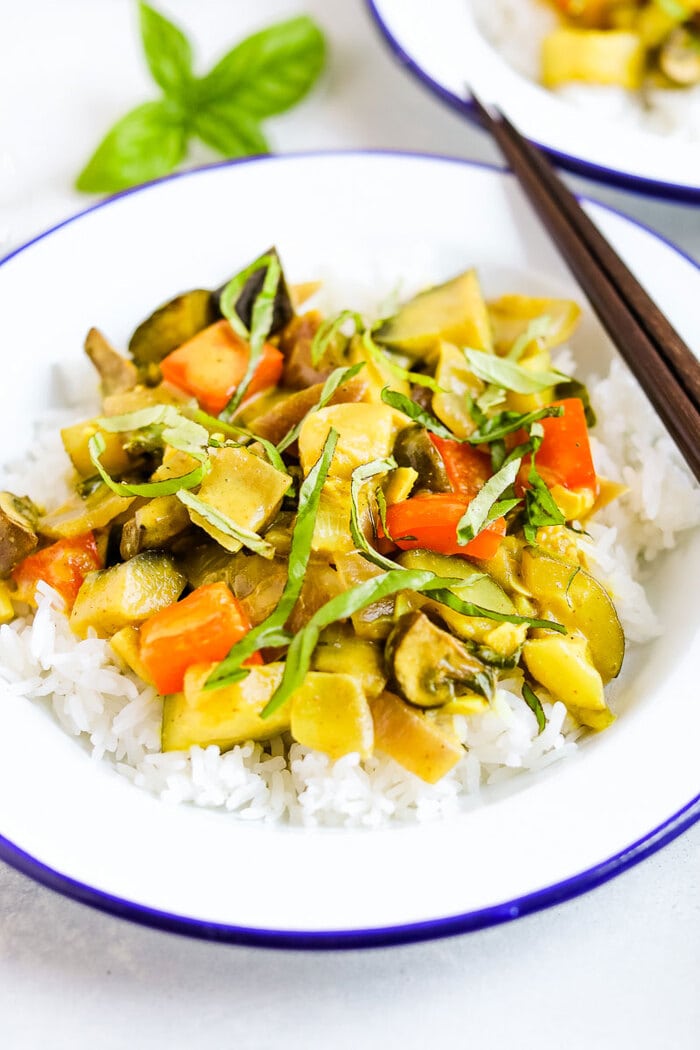 Summer vegetable curry served over rice and topped with fresh basil.