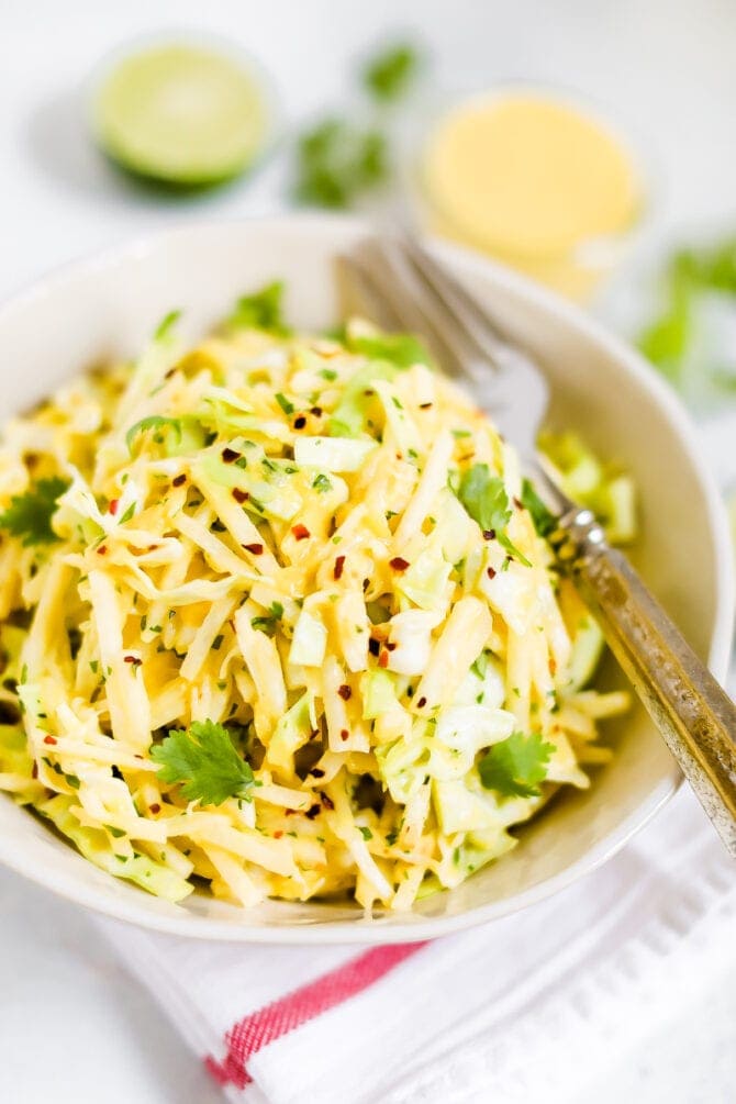 Jicama slaw in a bowl with a fork.