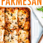 Casserole dish with baked eggplant parmesan sliced into pieces.