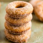 Stack of baked apple cider donuts on a tray.
