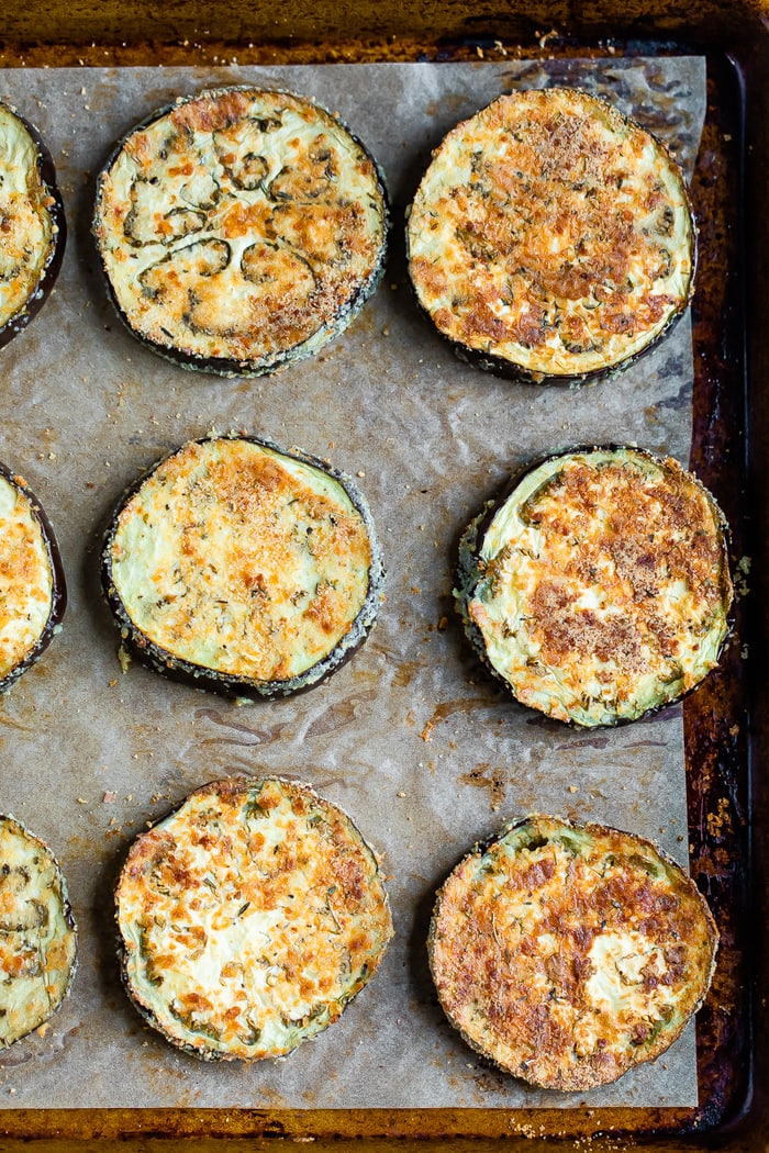 Slices of eggplant coated with almond flour and baked until crispy on a baking sheet.