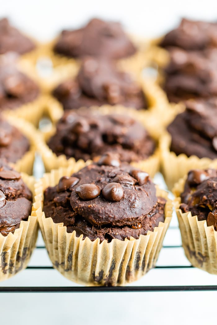 Double chocolate protein muffins in muffin liners on a cooling rack.