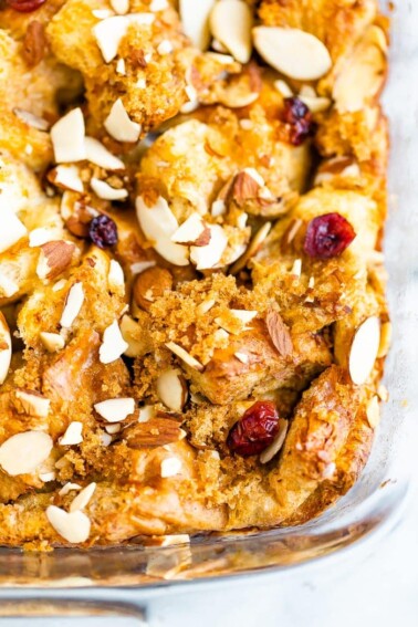 Top of a french toast bake, topped with brown sugar, cranberries, and almonds.