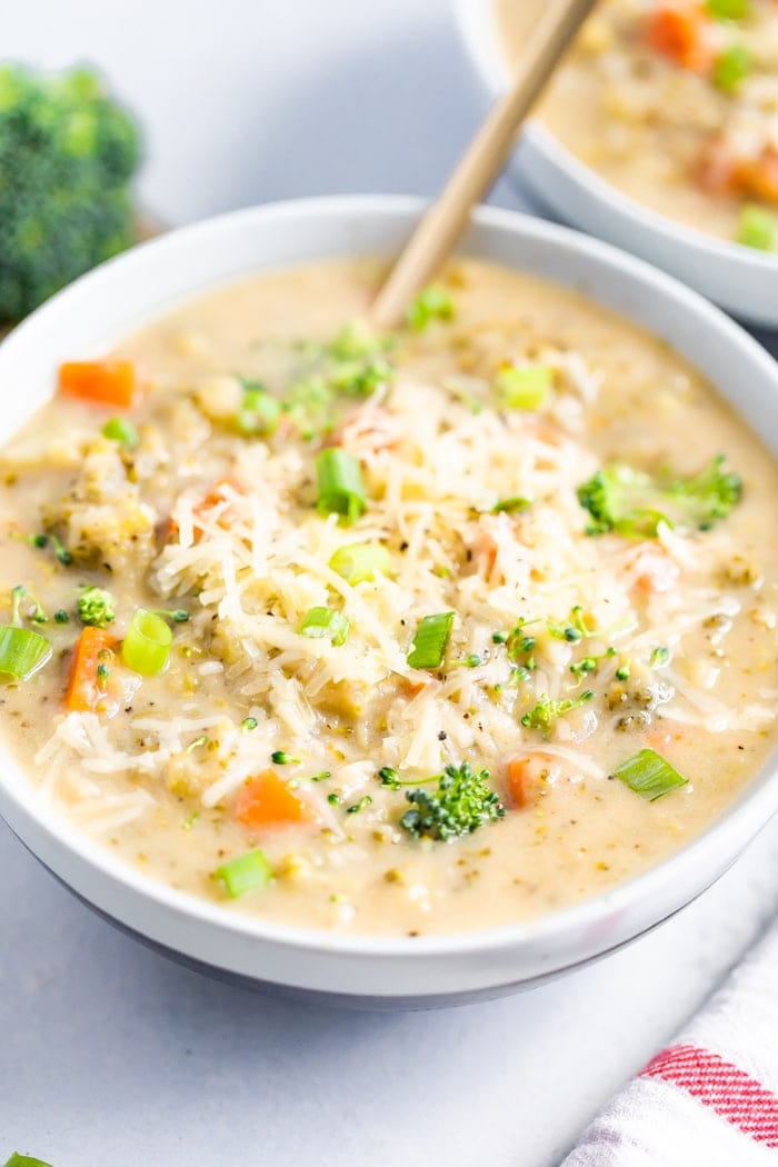 Bowl of broccoli cheddar soup with a gold spoon in the bowl.