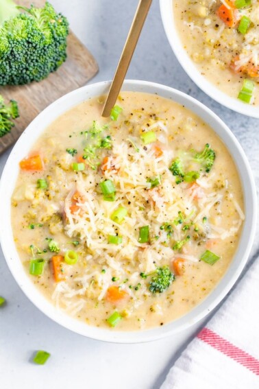 Bowl of broccoli cheddar soup with a gold spoon in the bowl.