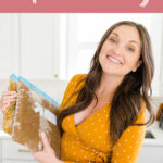 Pregnant woman holding freezer bags with meal prep freezer meals.