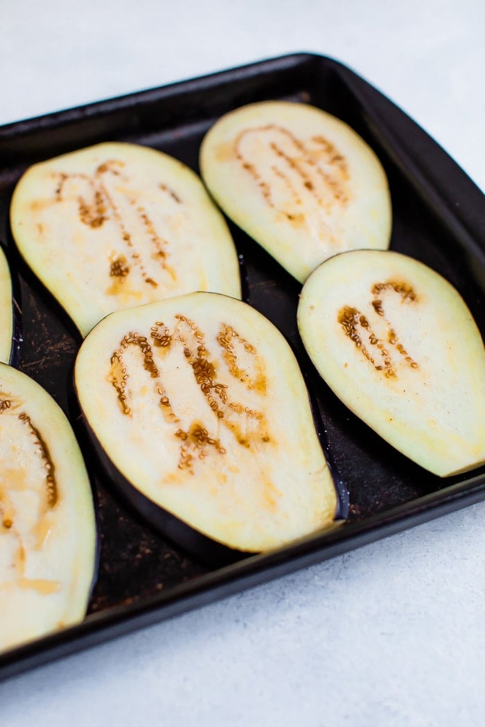 Sheet pan with slices of eggplant with salt on them, preparing for the casserole.