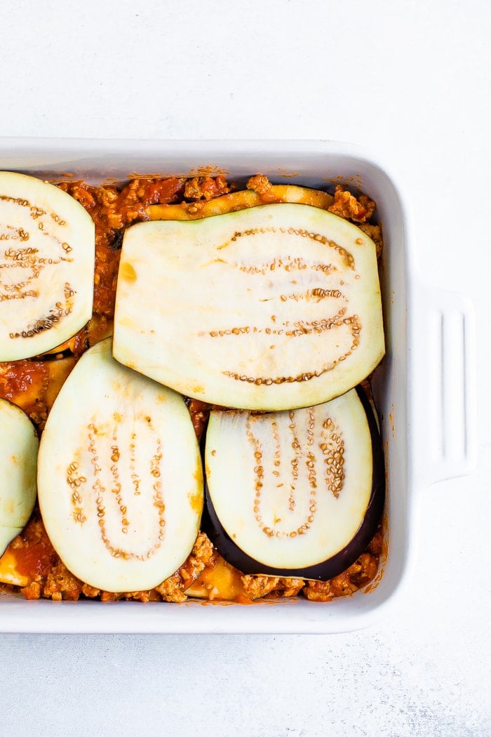 Casserole dish with turkey meat sauce layered with slices of eggplant.